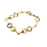 A 9ct two colour gold bracelet, formed as pairs of snaffle bits, on a snap clasp, 15.7g.