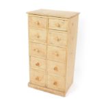 A pine chest of drawers, with ten drawers, raised on a plinth base, 99cm H, 53cm W, 37.5cm D.