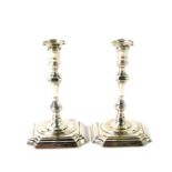 A pair of George V silver miniature candlesticks, of 18thC style baluster form, raised on stepped