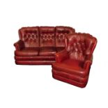 A Mansfield Upholstery red leather three seater sofa, with button back cushions, raised on