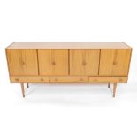 A 1960's teak sideboard, with two pairs of doors, above three drawers, raised on turned legs,