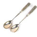A pair of Chinese salad servers, white metal, the handles embossed with berries and flowers, stamped