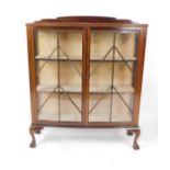 An early 20thC mahogany bow front display cabinet, with two glazed doors opening to reveal two