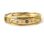 A Victorian 9ct gold sapphire and diamond bangle, on a snap clasp with safety chain as fitted, 13.