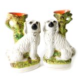 A pair of Staffordshire late 19thC flatback pottery spill vases, moulded as seated spaniels