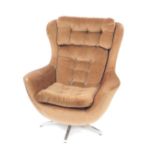 A Parker Knoll 1970s swivel egg chair, upholstered in brown button back draylon, raised on a five