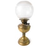 A duplex early 20thC brass oil lamp, with embossed rococo scroll and foliate decoration, with a