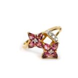 An 18ct gold padparadscha sapphire and diamond ring, in a double flower banded setting, size O, with