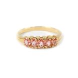 An 18ct gold and Ceylon padparadscha sapphire five stone ring, with certificate, approx 0.7cts, size