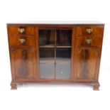 A Georgian style mahogany bookcase, with a glazed central door enclosing three shelves, flanked by