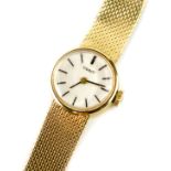 A Tissot lady's 9ct gold circular cased wristwatch, champagne dial bearing gilt batons, on a 9ct