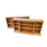 A pair of chestnut and cross banded break front bookcases, each with six shelves, flanked by semi