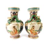 A pair of early 20thC Japanese earthenware vases, of baluster form, moulded with dragons,