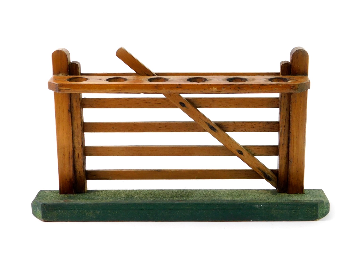 An early 20thC oak pipe rack, formed as a six bar gate, on a green beize covered base, 28cm W.