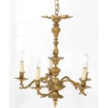 An 18thC style brass six branch chandelier, the arms cast as scrolling leaves, on a baluster stem,