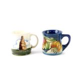 A Moorcroft pottery mug, decorated in the Bottle Kiln pattern, and a further mug decorated in the