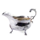 A George V silver sauce boat, with an S scroll handle, raised on three hoof feet, Sheffield 1917,