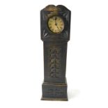 A late 19thC American brass cased bedside clock, contained in a miniature ebonised long case clock