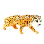 A Beswick figure of a cheetah, modelled in standing pose, printed mark and paper label, 29cm W.