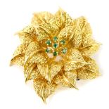 An 18ct gold and emerald set floral brooch, of three tiered petal form, 19.6g.