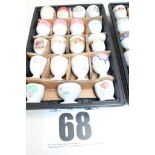 TRAY & CONTENTS OF 19 WHITE FLORAL PAINTED PEDESTAL EGG CUPS.