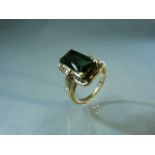 Hand crafted gold ring set with large Green Emerald cut Tourmaline and channel set diamonds to