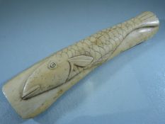 Scrimshaw - A piece of bone carved with a simple single fish.
