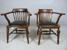 Two oak leather seated captains chairs