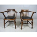 Two oak leather seated captains chairs