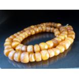 Butterscotch Amber bead necklace set with approx 65 disc shaped beads on string. approx weight 43g