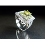 White Gold Diamond ring with central princess cut Yellow Diamond flanked with Eight Brilliant cut