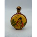 Unusual oriental snuff bottle of enamel over metal. The circular bodied bottle with two enamelled