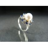 Pearl Ring: approx 7.8mm cultured pearl surrounded by 8 small diamonds and with an outer ring of 8