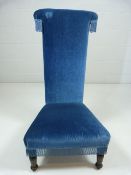 Tall backed blue upholstered antique bedroom chair with tassled sides.