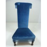 Tall backed blue upholstered antique bedroom chair with tassled sides.