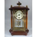 Mantle clock in brass and bevelled glass case and with wooden outer case with two columns and