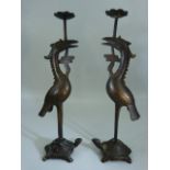 Bronze candlesticks modelled as a pair of cranes standing upon the back of Tortoises. Poss Chinese.