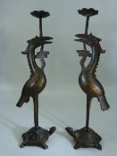 Bronze candlesticks modelled as a pair of cranes standing upon the back of Tortoises. Poss Chinese.