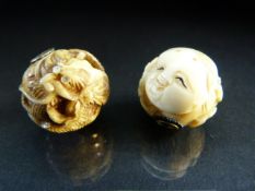 Two Japanese ivory nestuke beads - 1 depicting mens faces and the other carved with dragon set