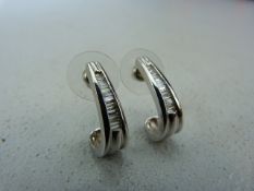 Pair of 14k White Gold earrings set with graduated baguette diamonds