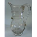 18th Century Georgian glass water jug with applied hollowed glass handle and a footed base. The bowl