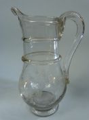 18th Century Georgian glass water jug with applied hollowed glass handle and a footed base. The bowl