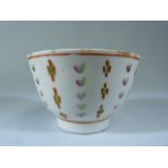 Miniature (unmarked) Sake cup. Decorated in underglaze Ochre, Green and Pink with floral stripes.