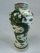 Small oriental vase depicting a five clawed dragon on white ground