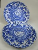 Pair of Scallop edge Japanese Blue and White plates depicting scenes of oriental men in a circular