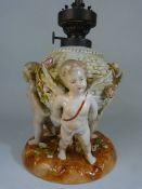 Schierholz Porcelain centrepiece converted to a lamp base. Three cherubs holding a woven basket,