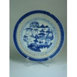 Oriental blue and white lattice ware dish. The centre depicting pagodas and river scene.