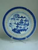 Oriental blue and white lattice ware dish. The centre depicting pagodas and river scene.