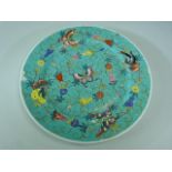 Oriental enamelled plate with turquoise ground depicting butterflies and flowers.