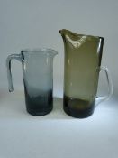 Holmegaard Danish glass water jugs in smokey glass. Both unmarked. 1 - approx height to spout